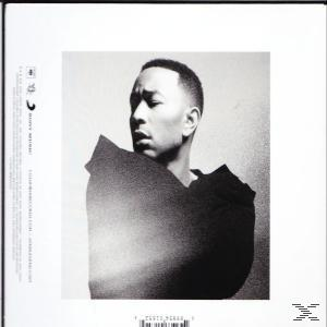 Schwarz-Weiß-Porträt von John Legend, der nach unten blickt. Er trägt ein dunkles Oberteil vor hellem Hintergrund, mit Text an der Seite.