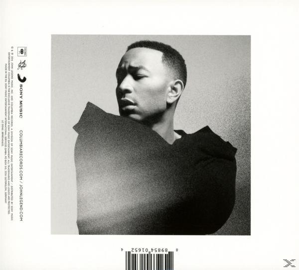 Schwarz-Weiß-Foto von John Legend. Er schaut nach unten mit ernstem Gesichtsausdruck. Er trägt ein dunkles Oberteil.