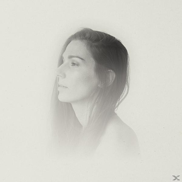Das Profil einer Frau in Monochrom, nach links blickend. Der Hintergrund ist ein verschwommener, heller Farbton, fast weiß.