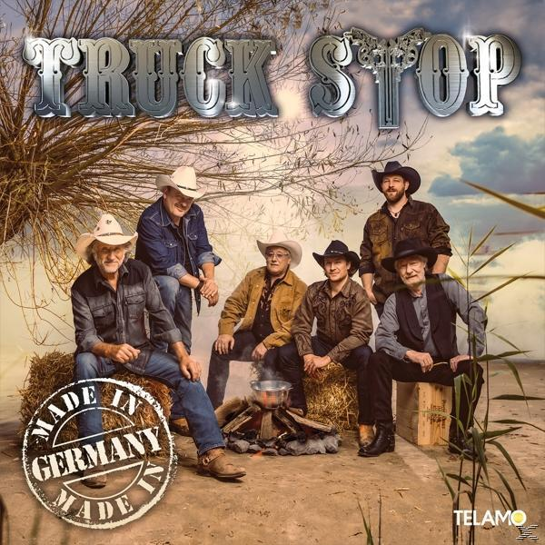 Truck Stop Albumcover. Die Bandmitglieder sitzen um ein Lagerfeuer. Made in Germany-Stempel ist sichtbar.