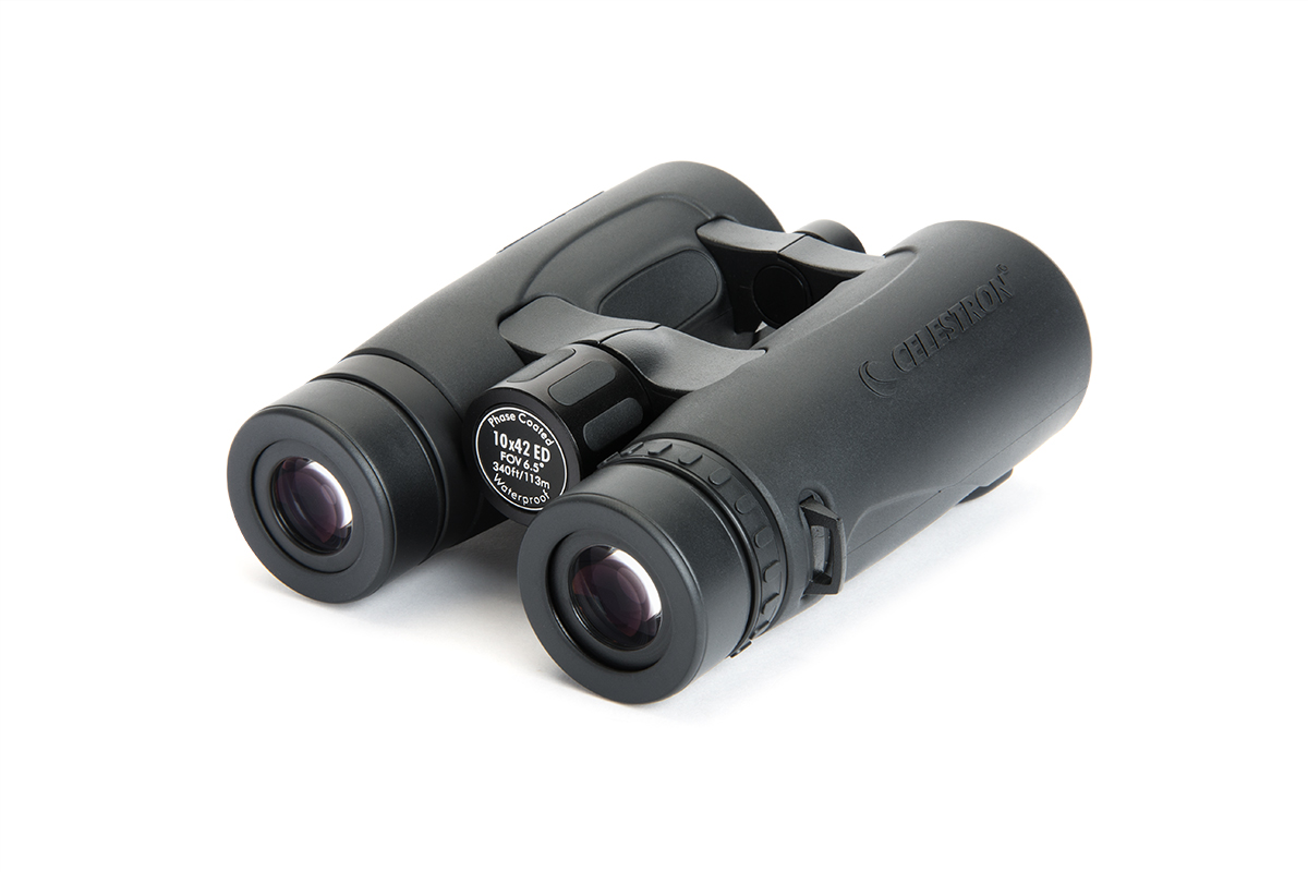 Zwarte verrekijker op een witte achtergrond. De verrekijker is gemarkeerd met 'Celestron' en '10x42 ED'.