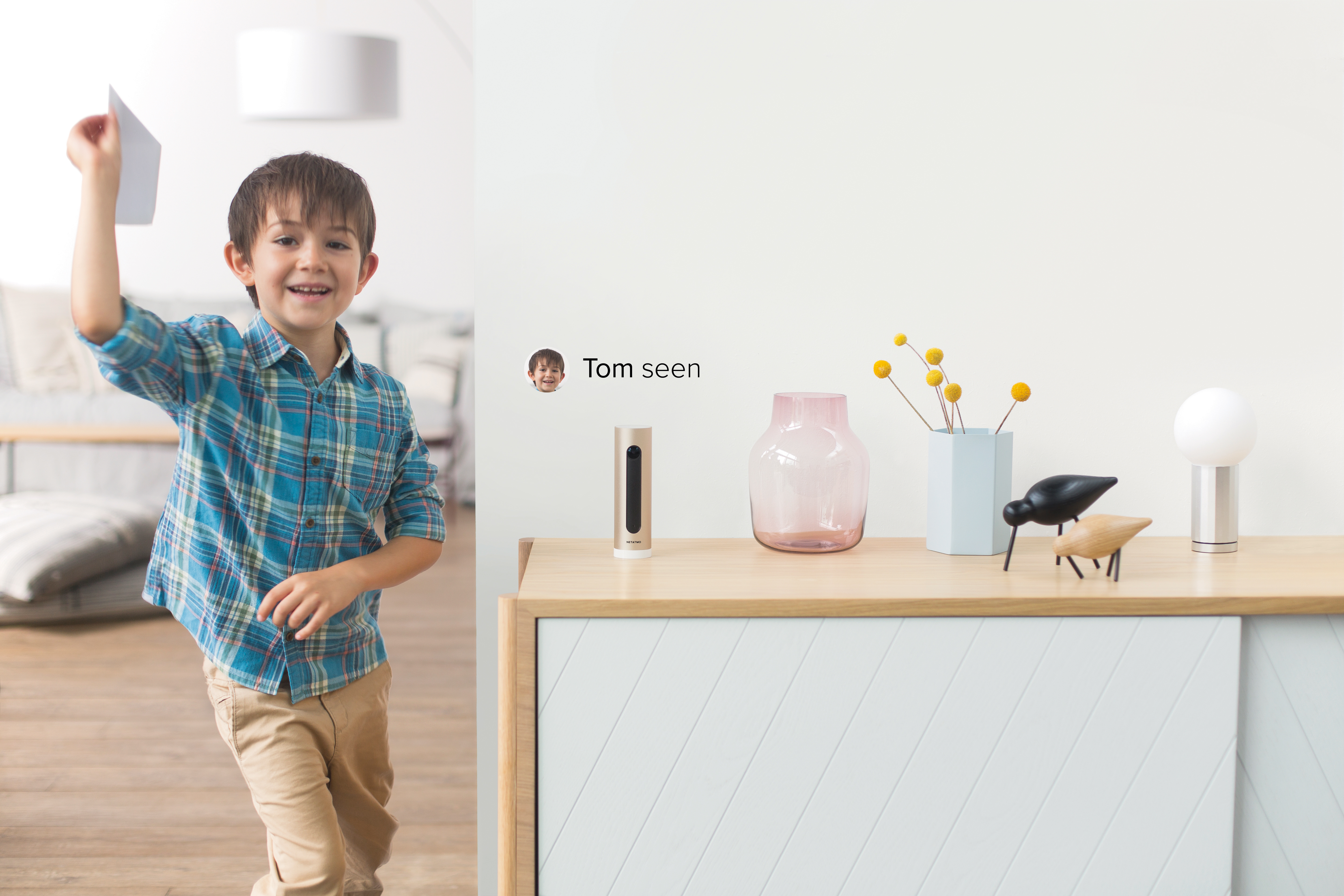 Garçon tenant du papier, souriant. Buffet avec décor et notification numérique.