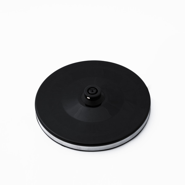 Black, circular base for an electric kettle. It has a silver band around the edge.