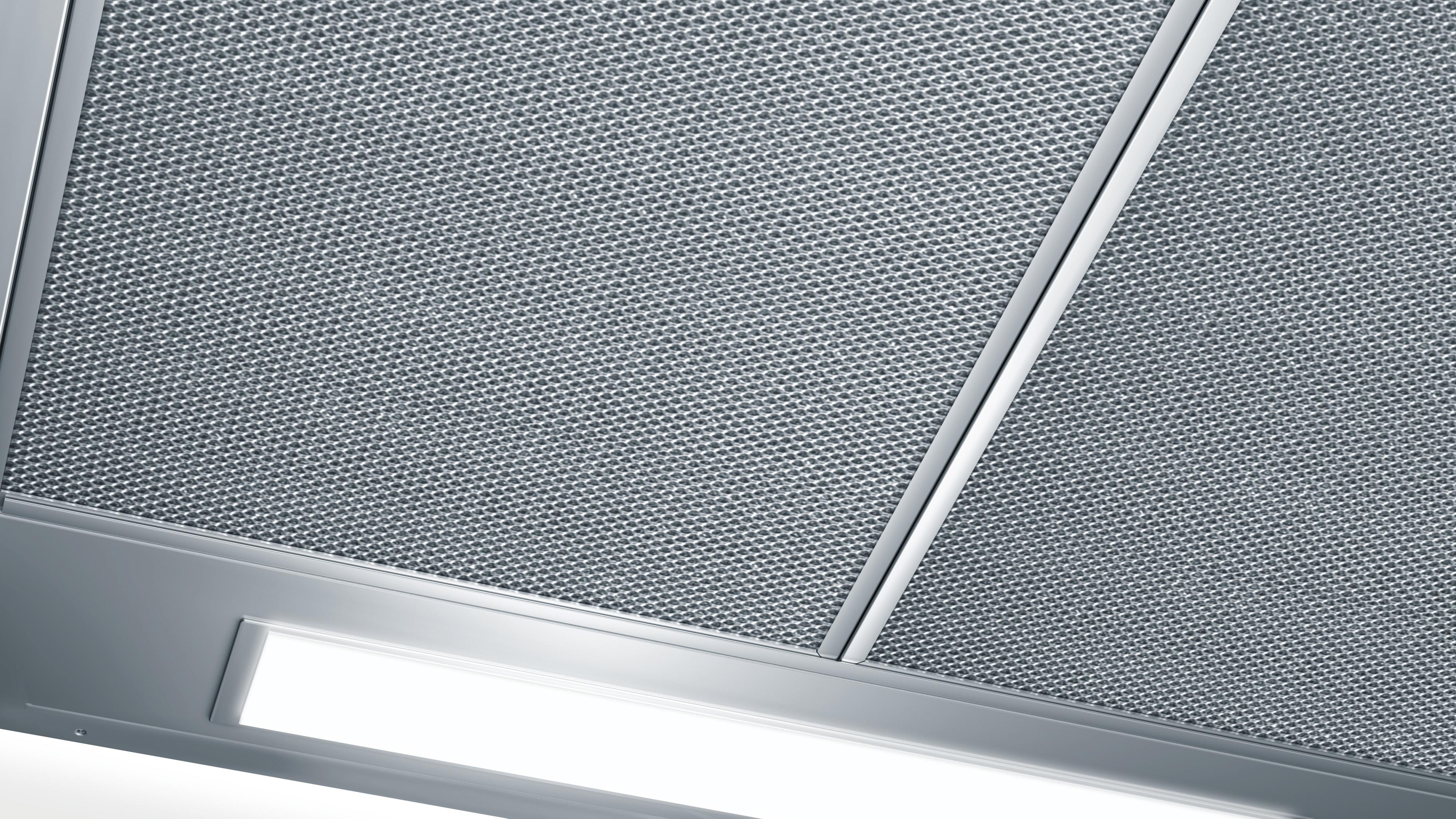 Close-up of a metal kitchen hood with mesh and a light.
