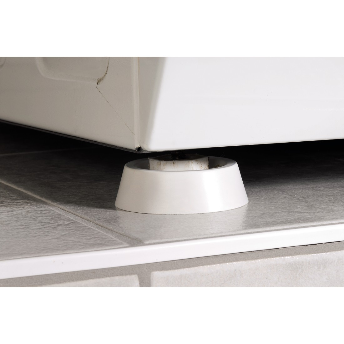 A white washer support, placed on a light-colored tiled floor.