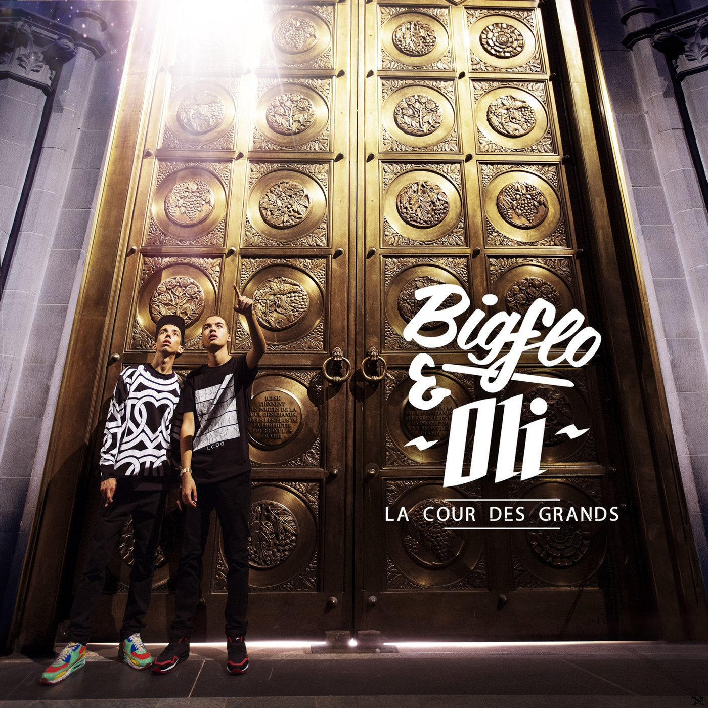 Albumhoes: Twee mannen voor gouden deuren. Titel: Bigflo & Oli - La Cour Des Grands. Licht schijnt neer.