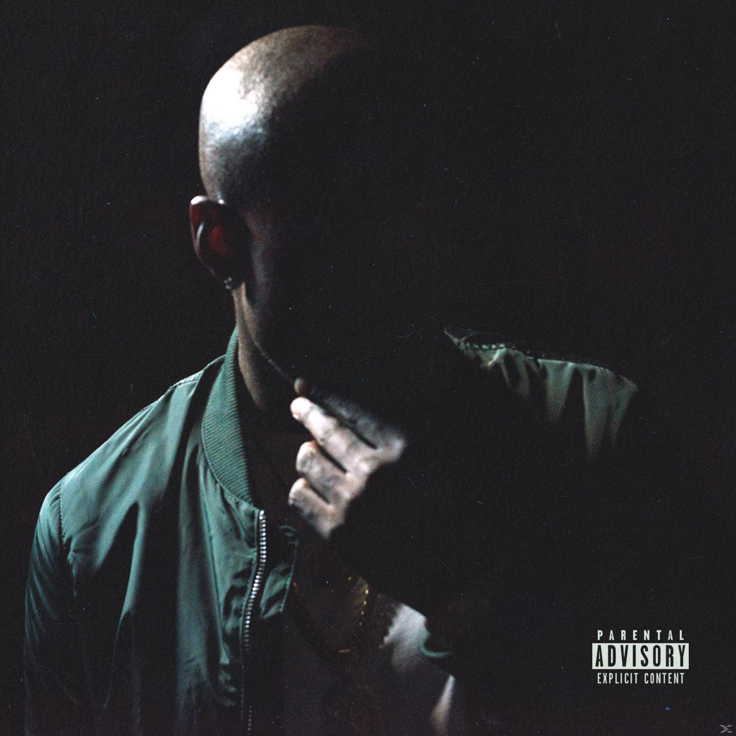 Pochette d'album : un homme en veste verte, visage obscurci, avec un autocollant d'avertissement parental.