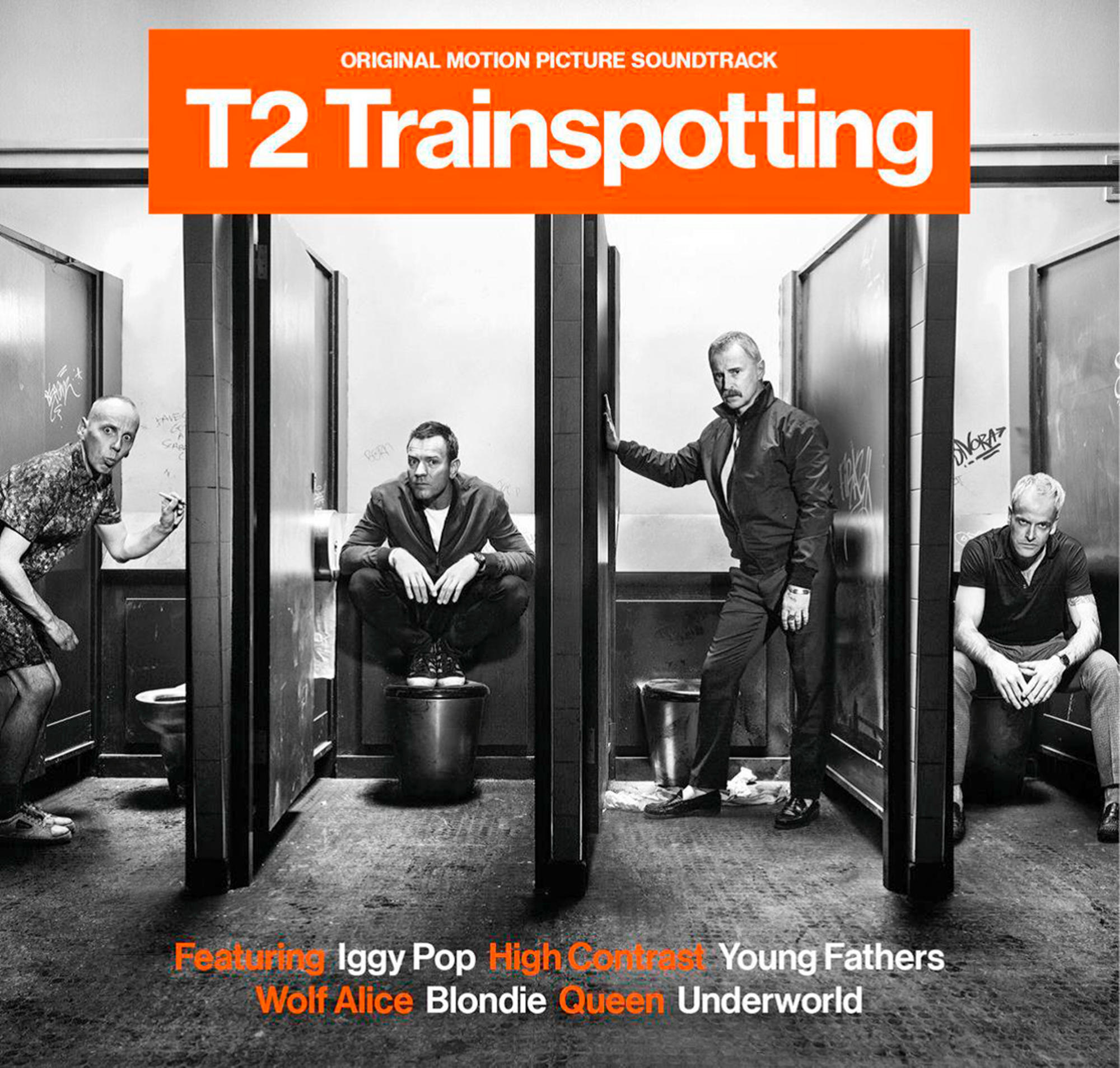 Vier mannen in een openbaar toilet. T2 Trainspotting soundtrack titel. Oranje en witte tekst. Grijswaardenafbeelding.
