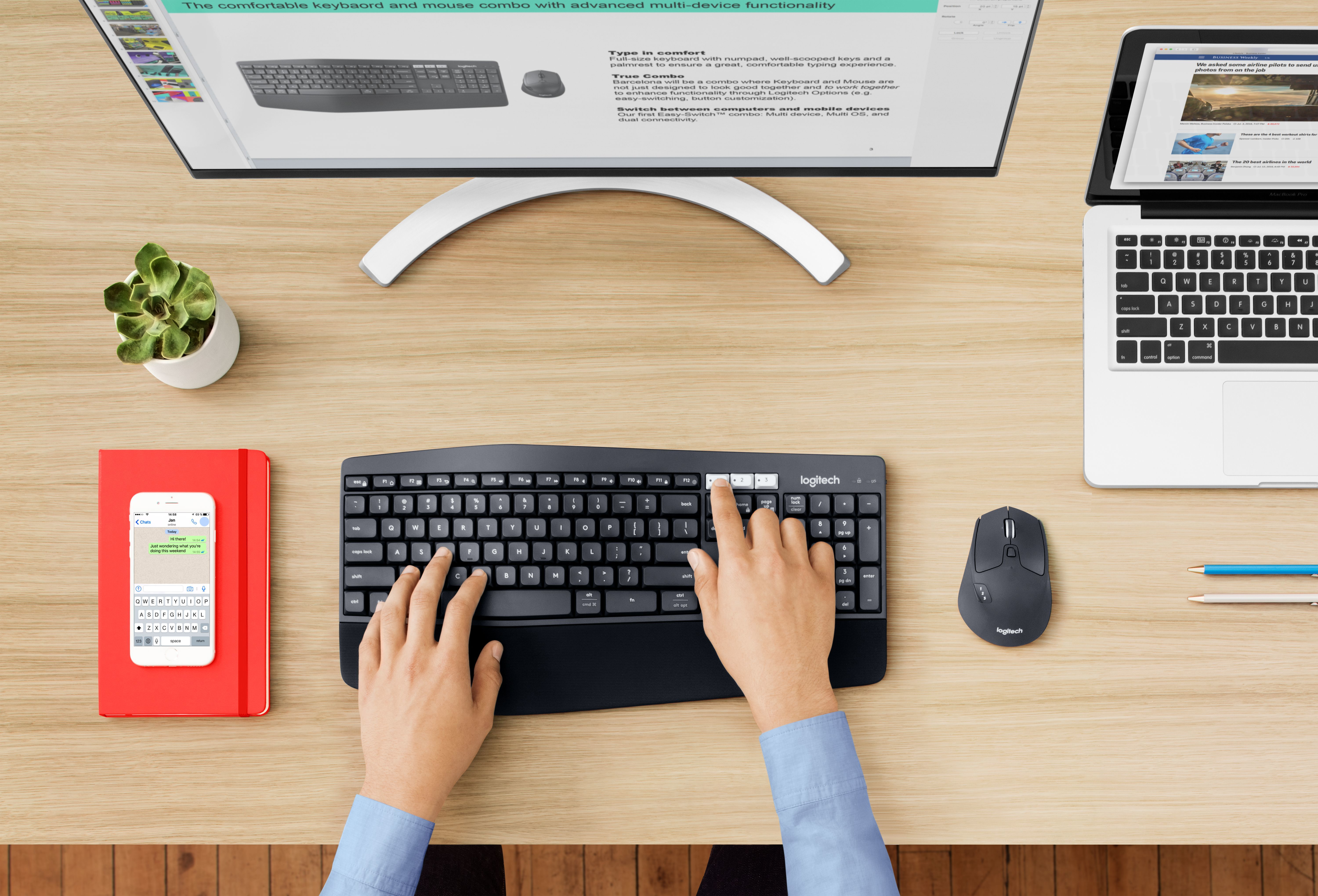 Draufsicht auf Schreibtisch mit Tastatur, Maus, Monitor, Tablet und Telefon.