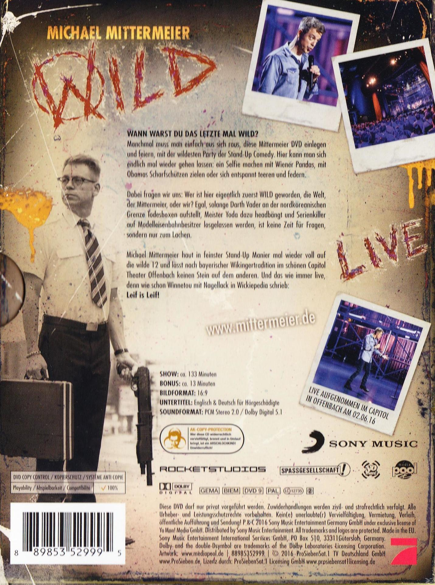 DVD-Cover für eine Comedyshow, mit einem Mann auf der Bühne und Text.