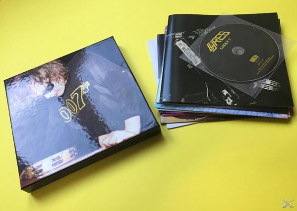 Eine gelbe Oberfläche mit einer schwarzen Box und einer CD mit einem Buch daneben.