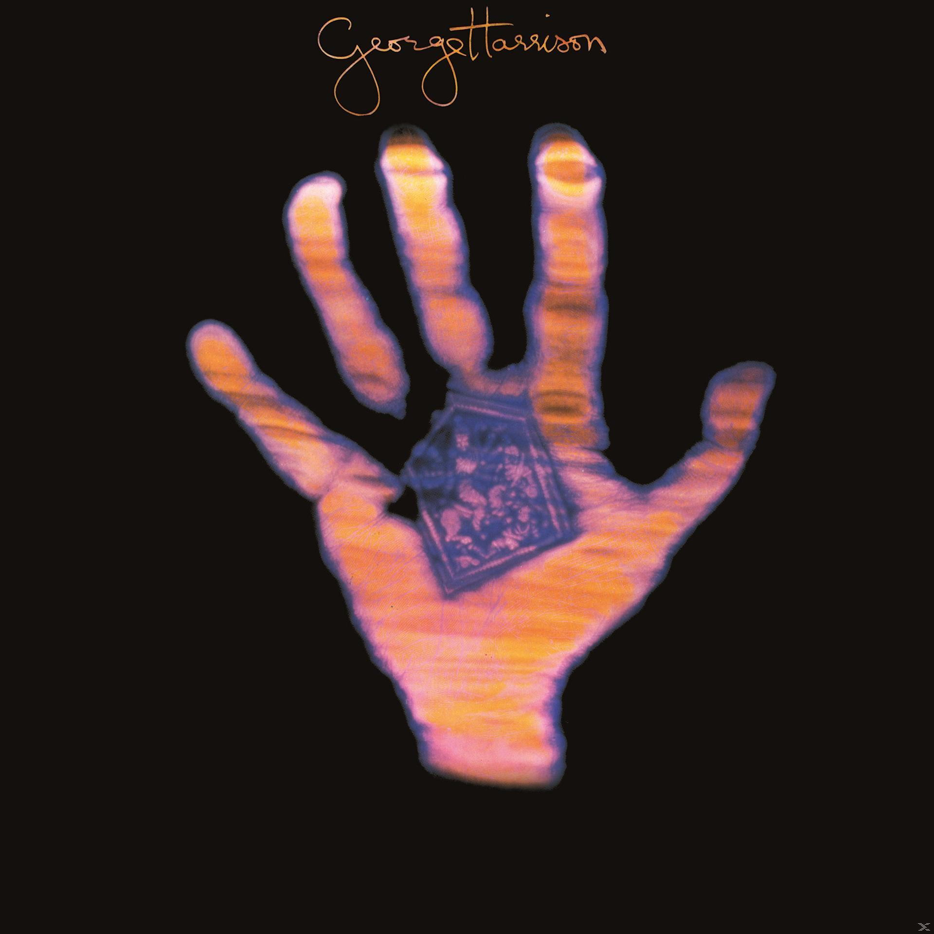 Pochette d'album avec une main dans les tons orange et une petite image. Fond noir.