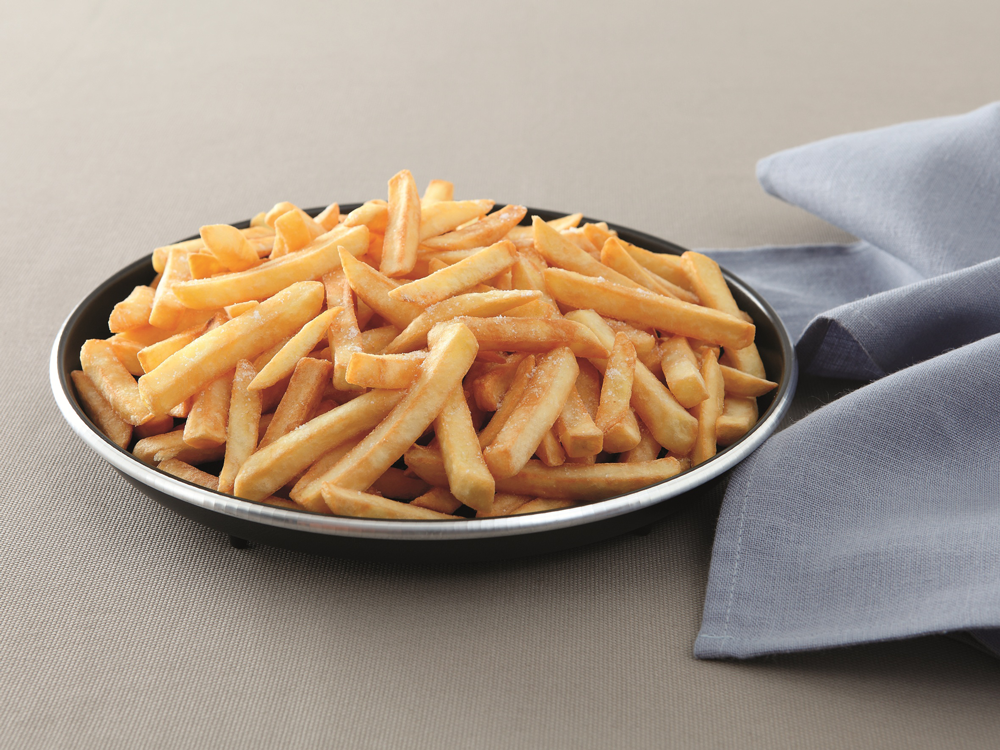Een zwart bord vol frietjes op een grijze achtergrond met een blauwe servet.