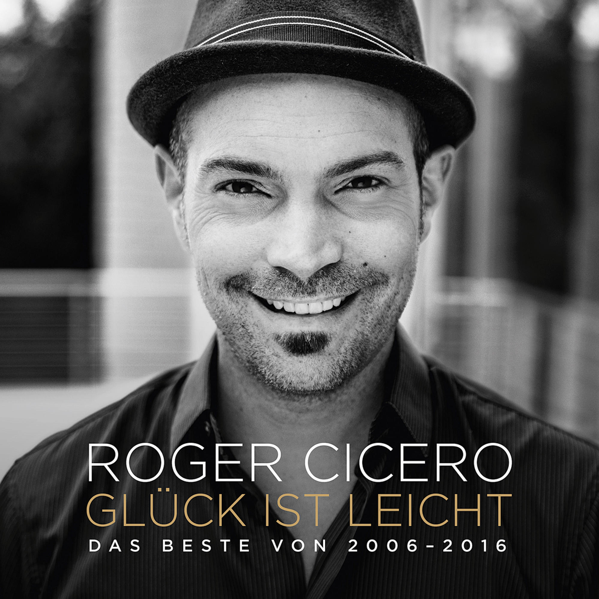 Schwarz-Weiß-Bild eines lächelnden Mannes mit Hut. Der Text unten lautet Roger Cicero.