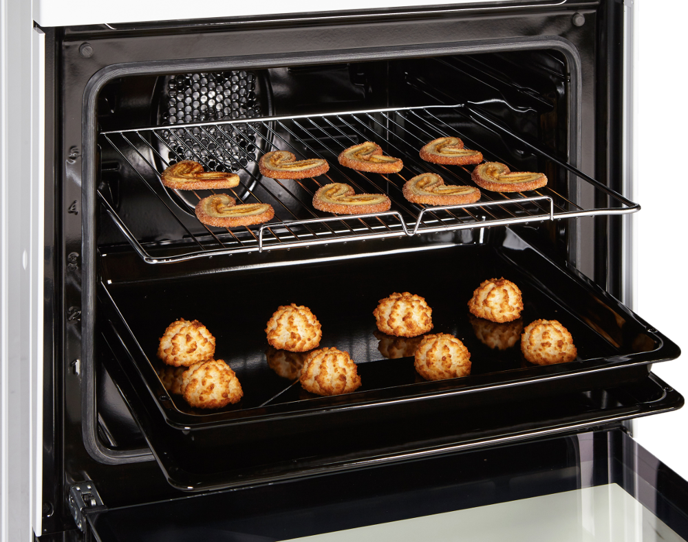 Oven interior, two racks with baked goods. Top rack: pastries. Bottom rack: cookies.
