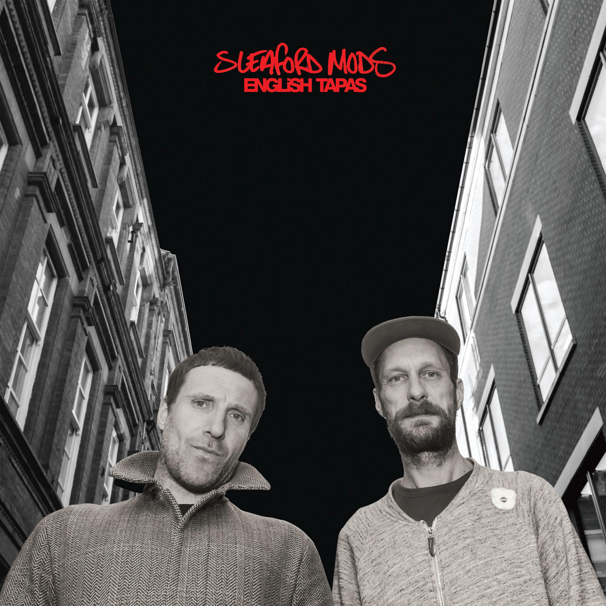 Sleaford Mods Albumcover mit zwei Männern vor einem Gebäude. Der Himmel ist schwarz.