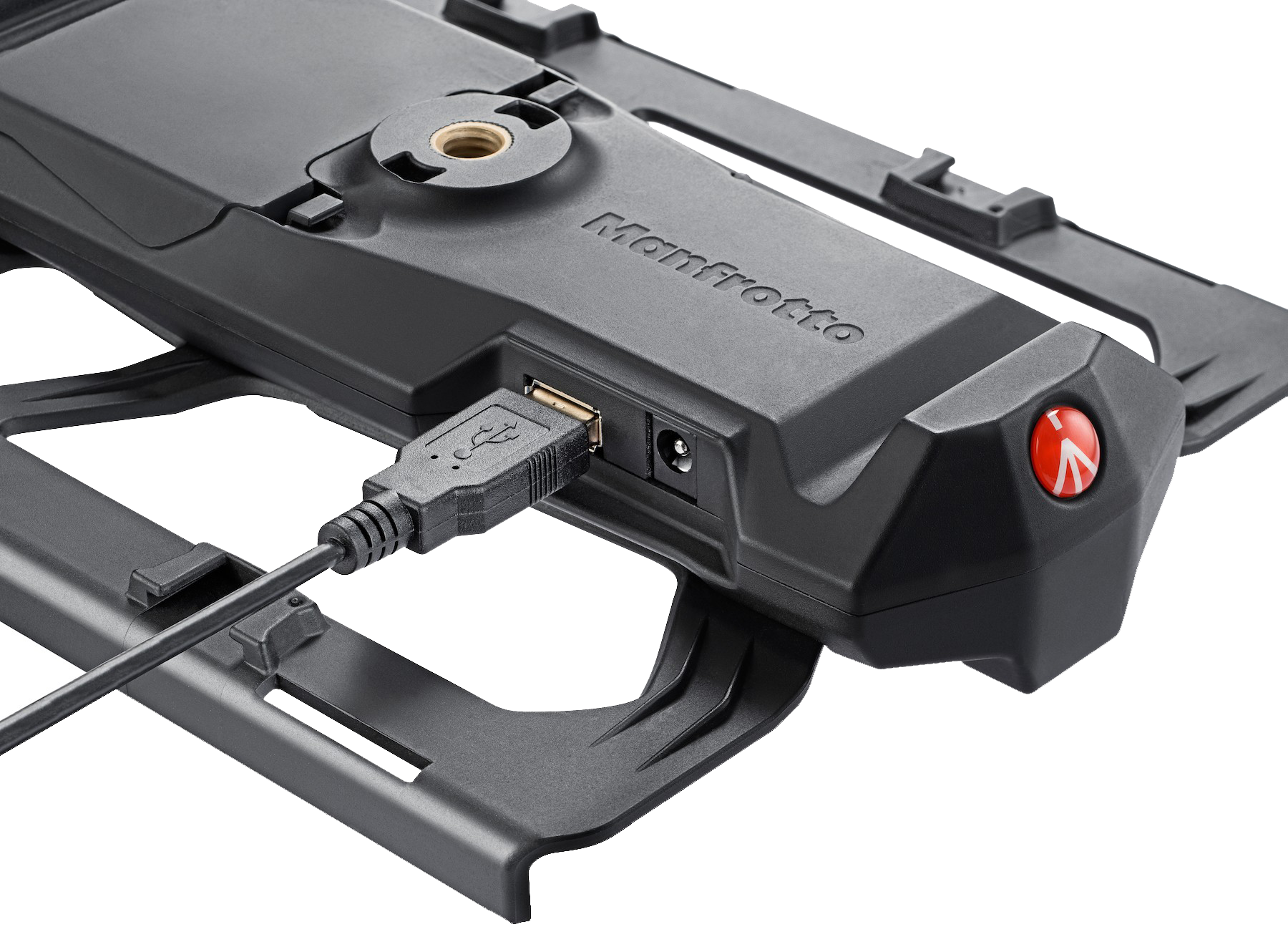 A black Manfrotto device is shown, with a USB cable plugged in. It has a red button and a mounting screw hole. The background is white.