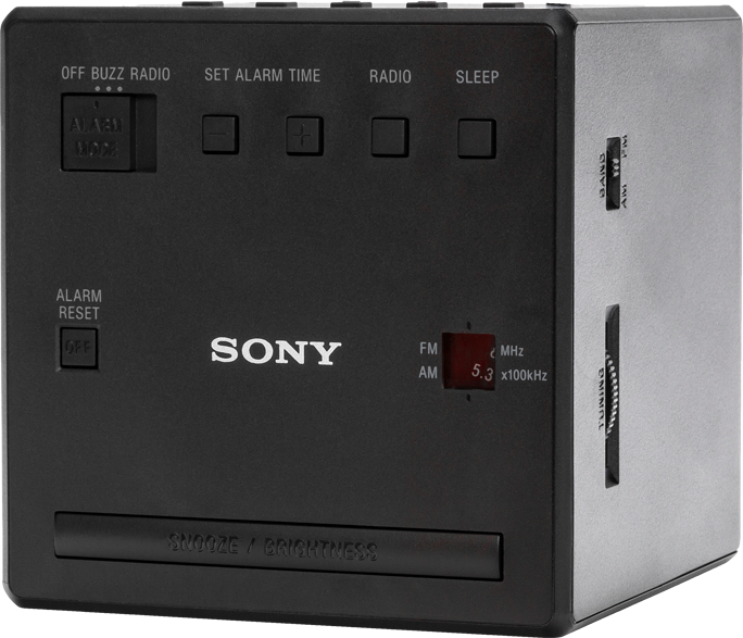 Egy fekete, kocka alakú Sony ébresztőóra gombokkal és digitális kijelzővel. A háttér fehér.