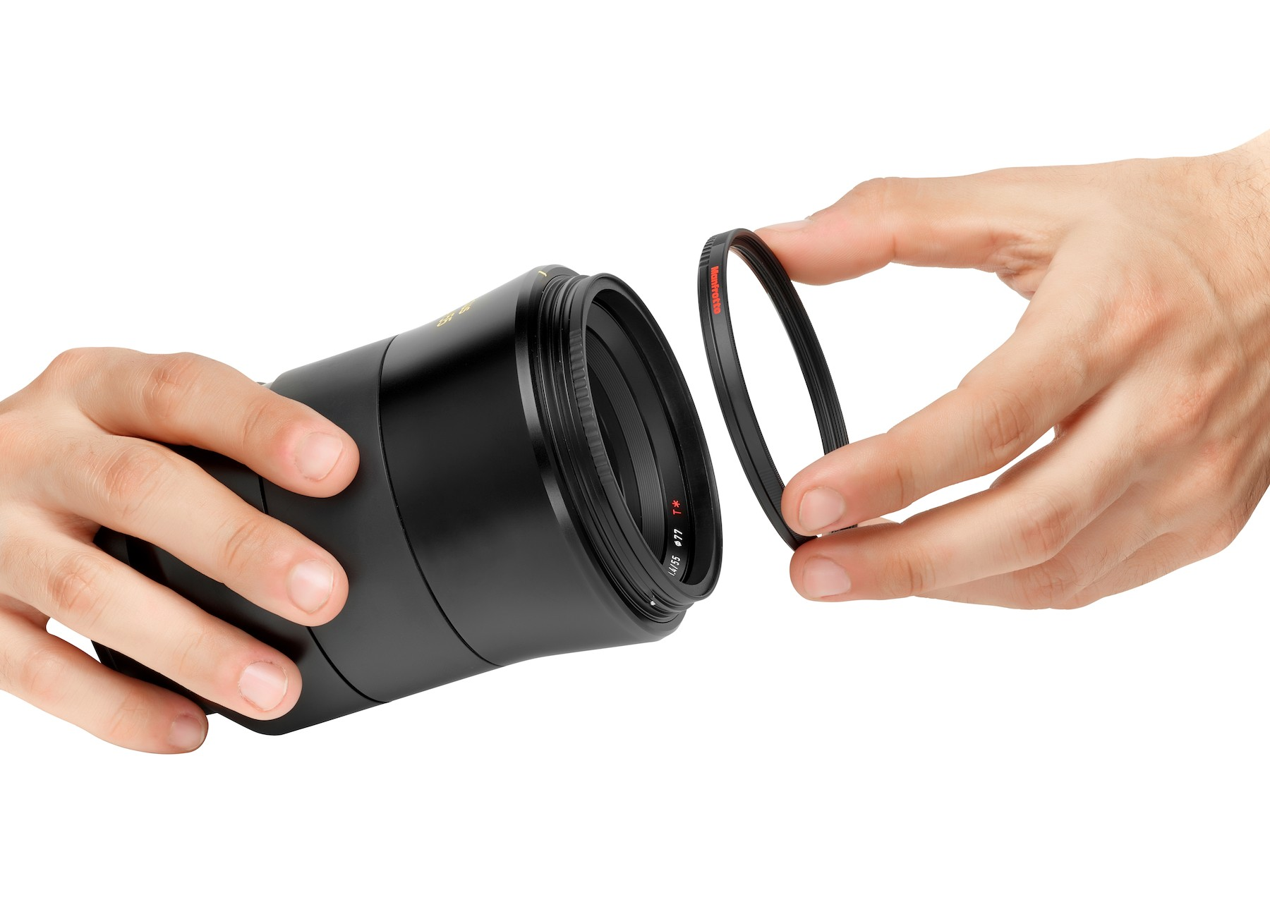 Hands assembling a camera lens with a red-ringed filter.
