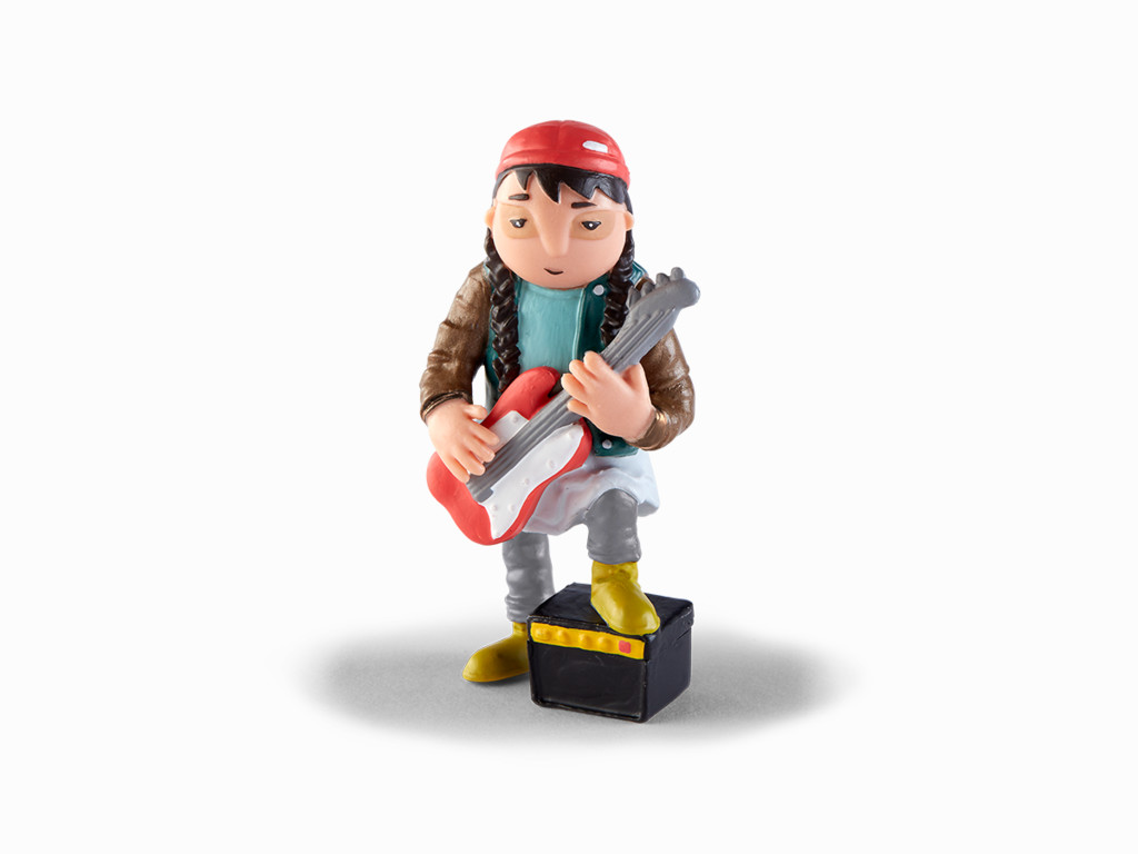 Eine Figur einer Person, die Gitarre spielt. Sie stehen auf einem schwarzen Verstärker, weißer Hintergrund.