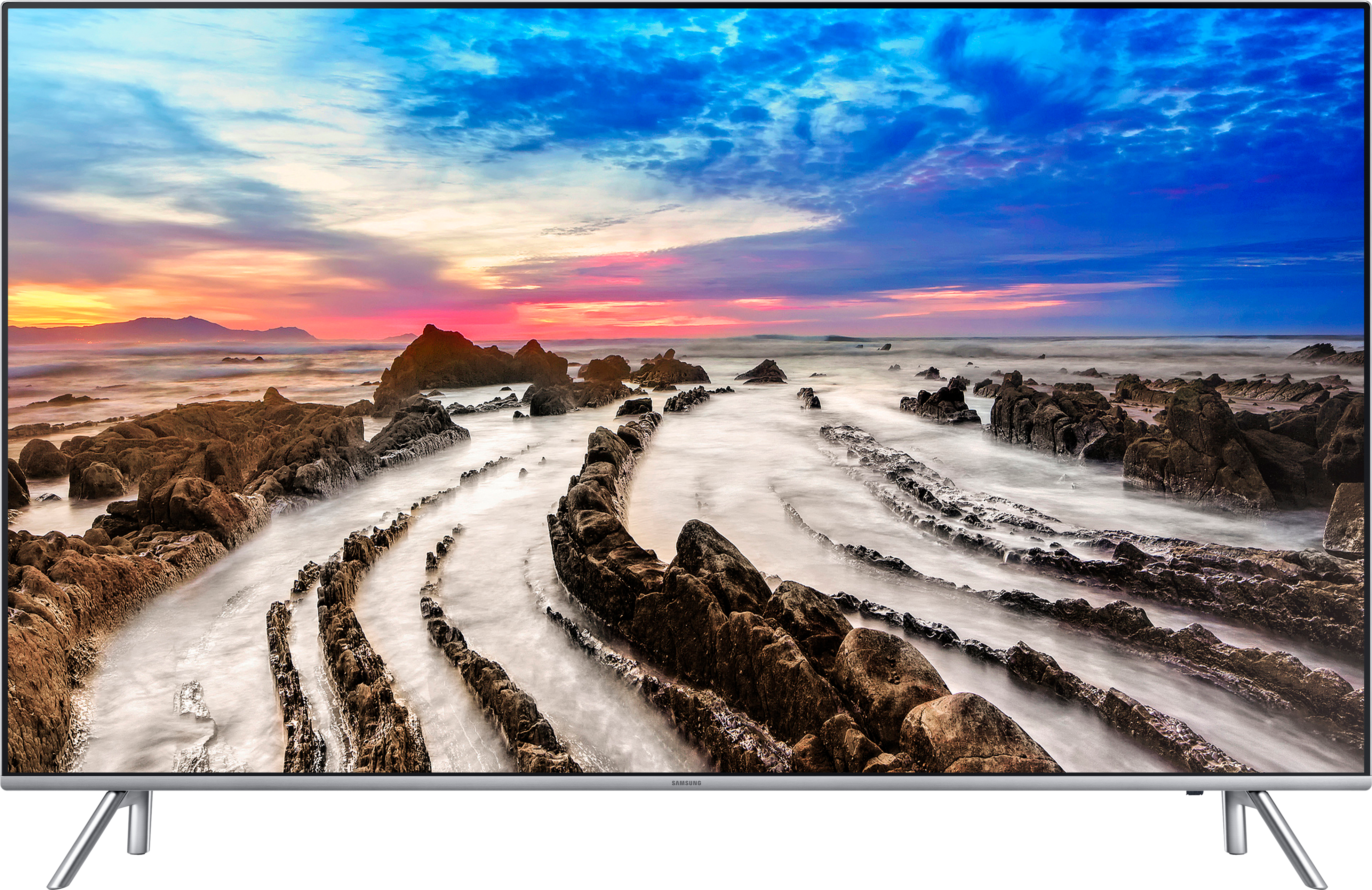 Flachbildfernseher mit einer Strandszene mit felsigem Vordergrund und farbenfrohem Himmel.