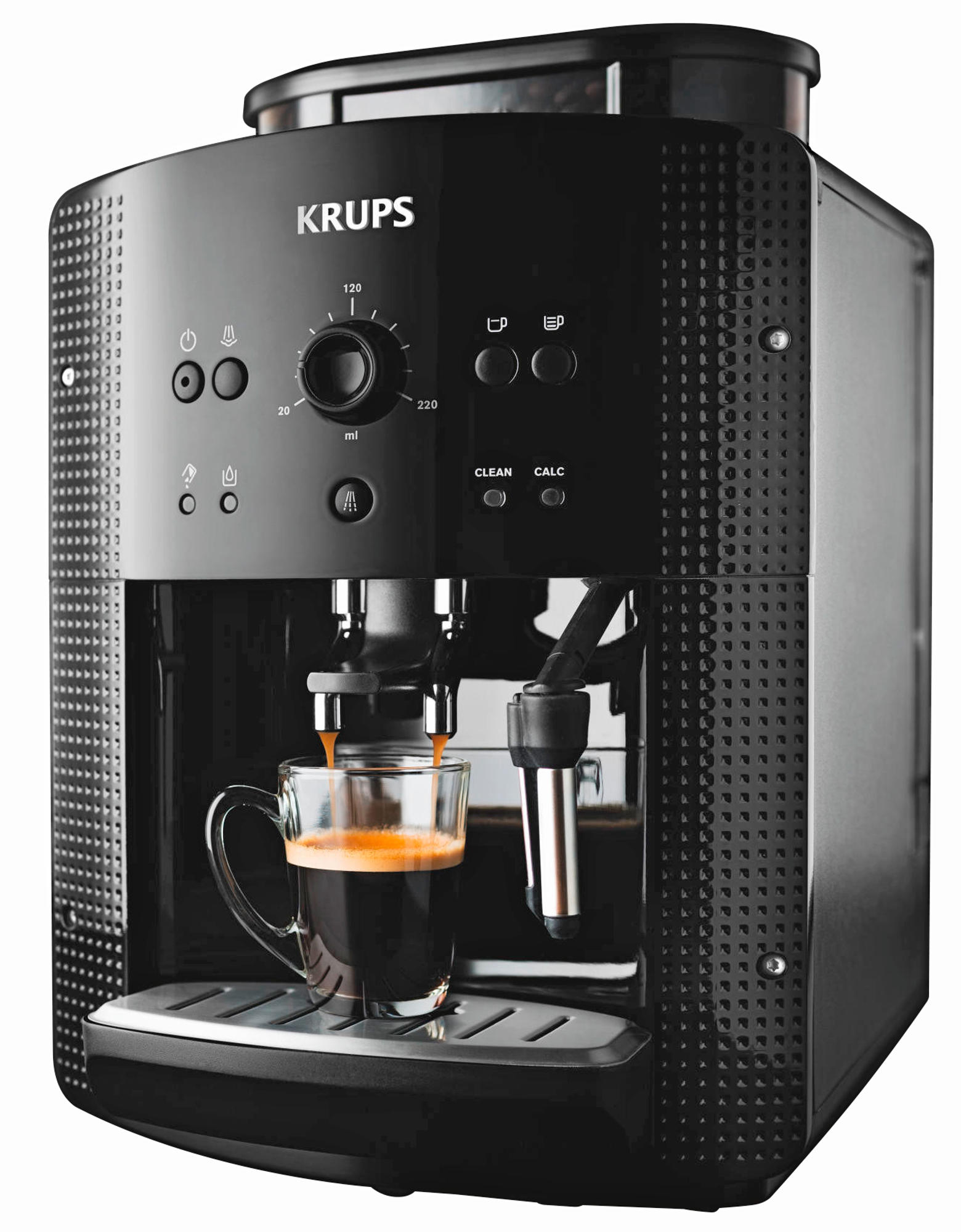 Una cafetera Krups negra con café vertiéndose en una taza de vidrio. La taza está en una bandeja.