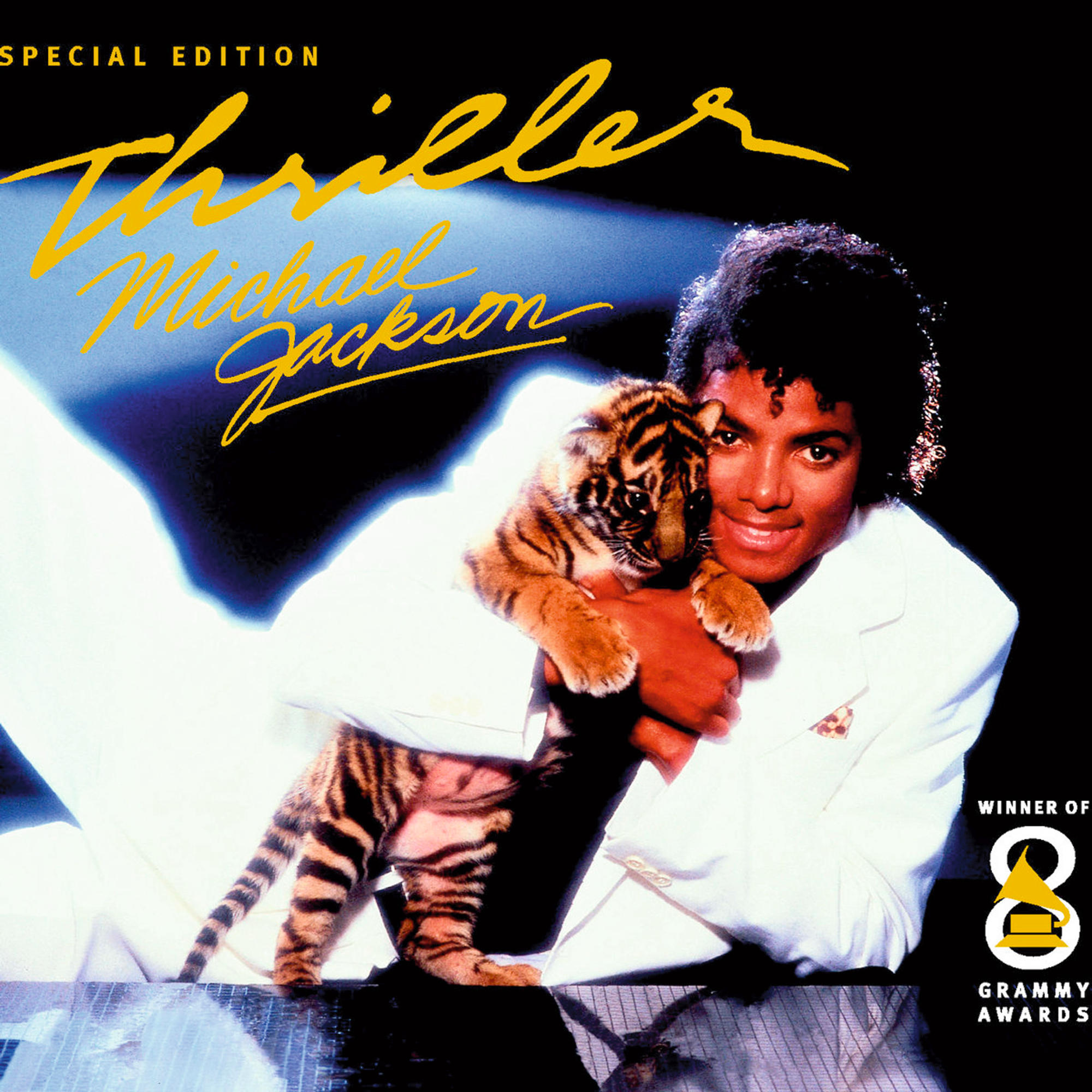 Michael Jackson auf dem Thriller-Albumcover, hält ein Tigerjunges. Er trägt einen weißen Anzug vor dunklem Hintergrund.