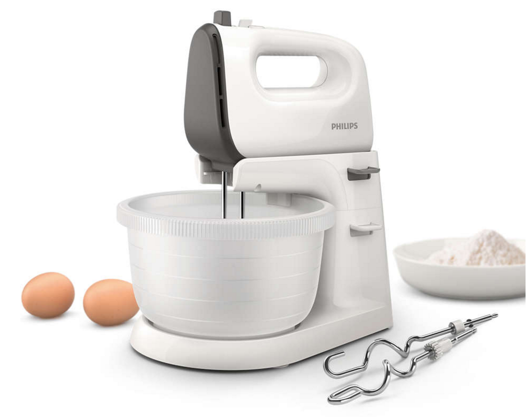 A white Philips hand mixer with a bowl, eggs, and flour, white background.