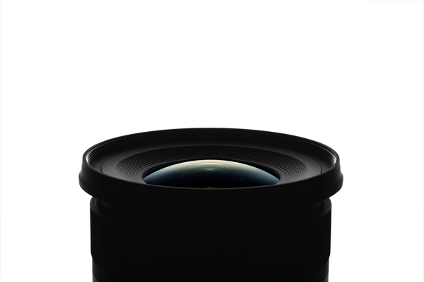 Close-up of a black camera lens, with a large front element, isolated on white.