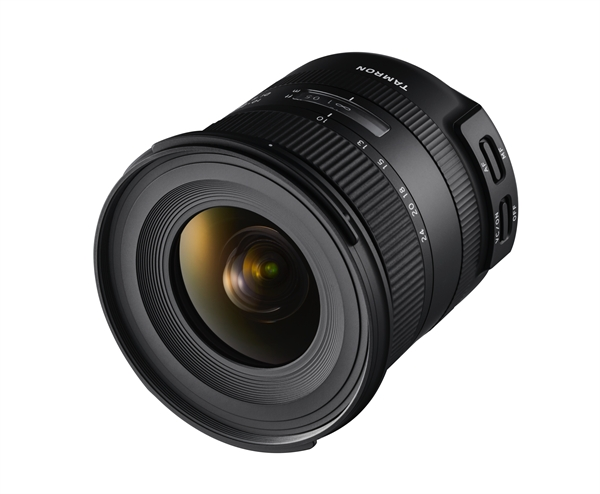 Black camera lens with Tamron text and a wide angle. The lens is angled to the left.