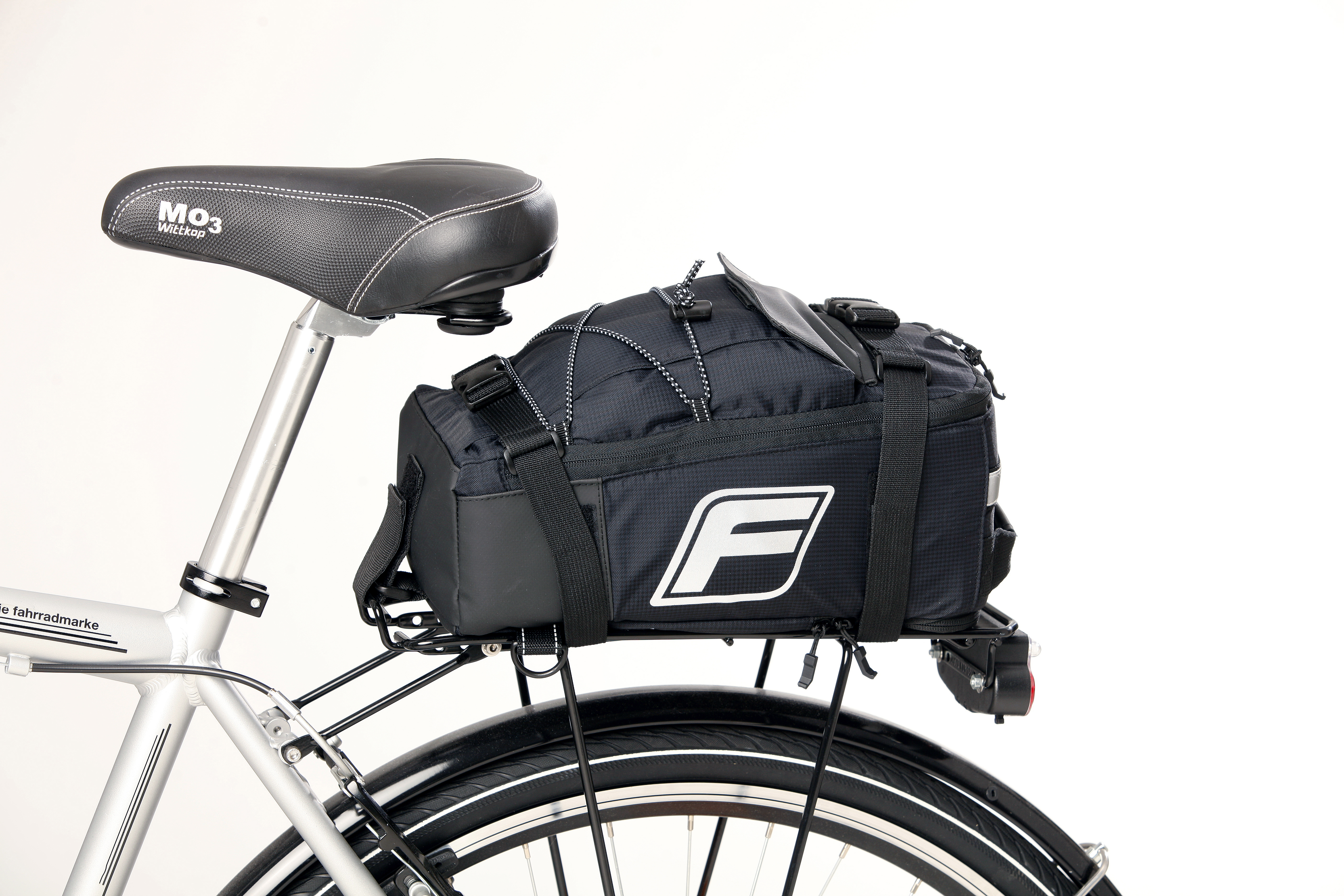 Schwarzes Fahrrad mit schwarzer Tasche hinten. F-Logo auf der Tasche.
