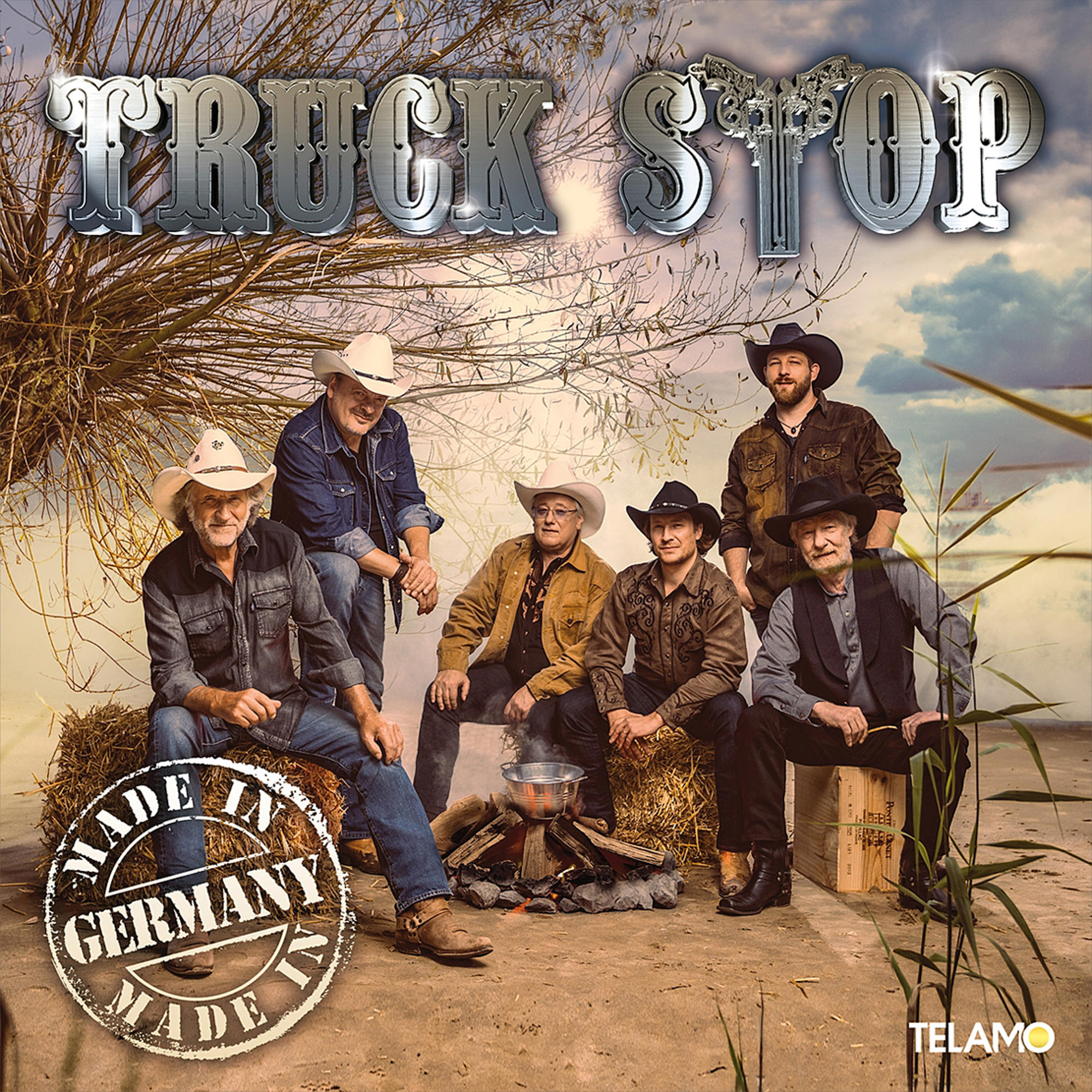 Albumcover mit sechs Männern, die sitzen. Landschaftshintergrund, mit Lagerfeuer und Truck Stop Schild.