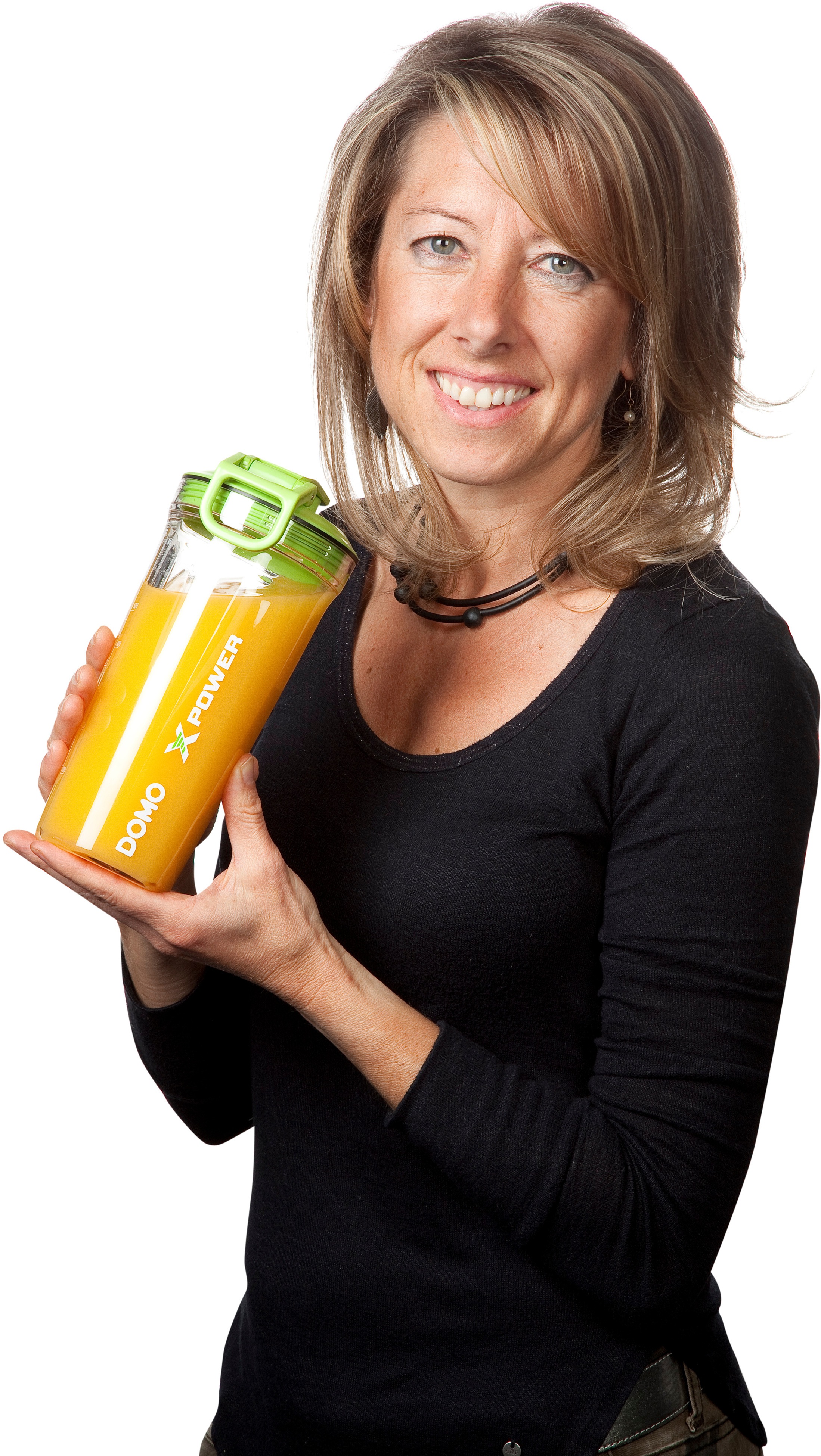 Femme tenant une bouteille de jus, souriant à la caméra. La bouteille dit 'DOMO X POWER'.