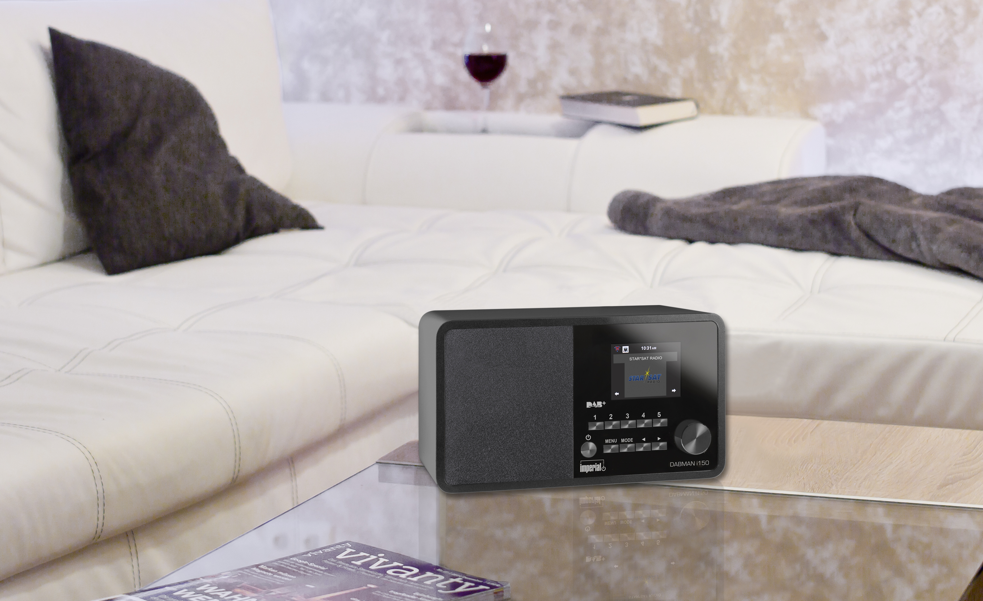 Moderne woonkamer met zwarte radio, witte bank, glazen tafel en wijnglas.