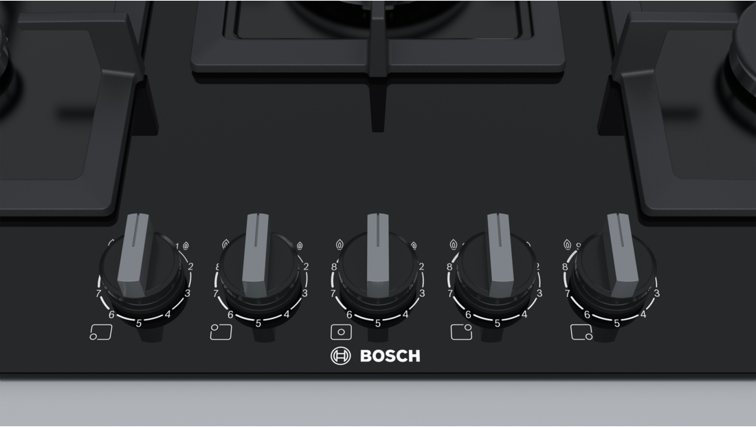 Black gas stove top with five knobs. Each knob is numbered with a flame symbol.