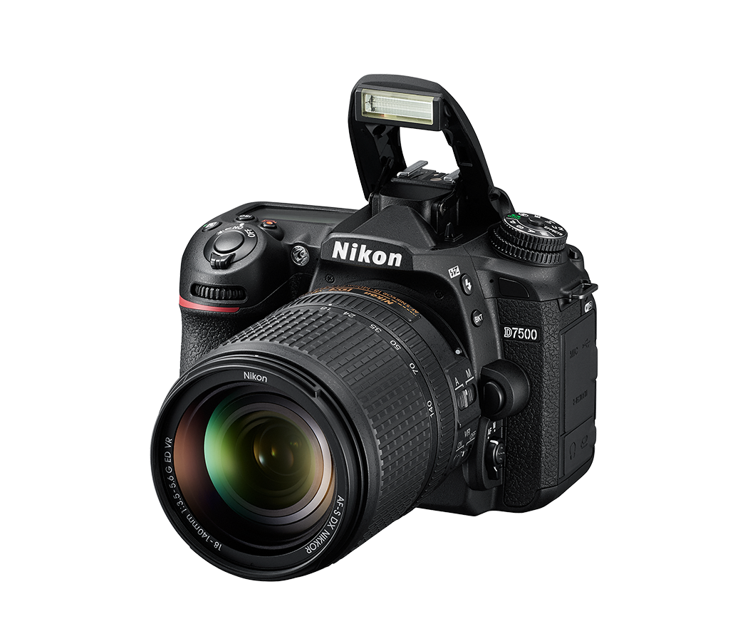 Nikon D7500 Kamera mit Objektiv und Blitz. Schwarzes Gehäuse, schräge Ansicht auf schwarzem Hintergrund.