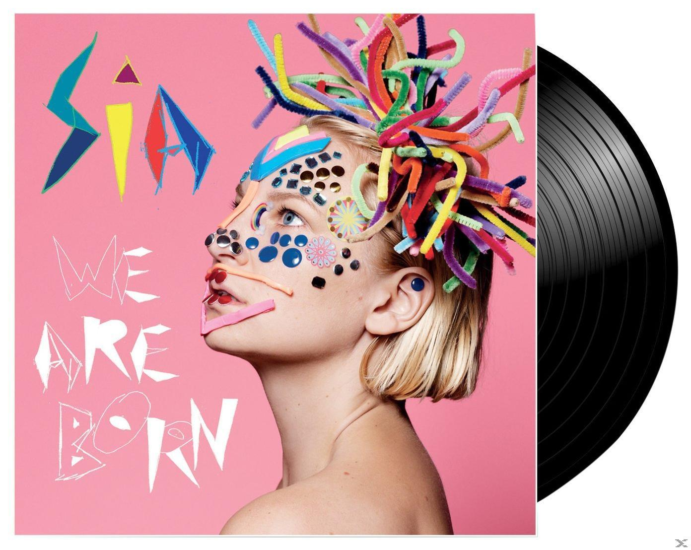 Sias Albumcover, mit ihrem geschmückten Gesicht, neben einer schwarzen Schallplatte.