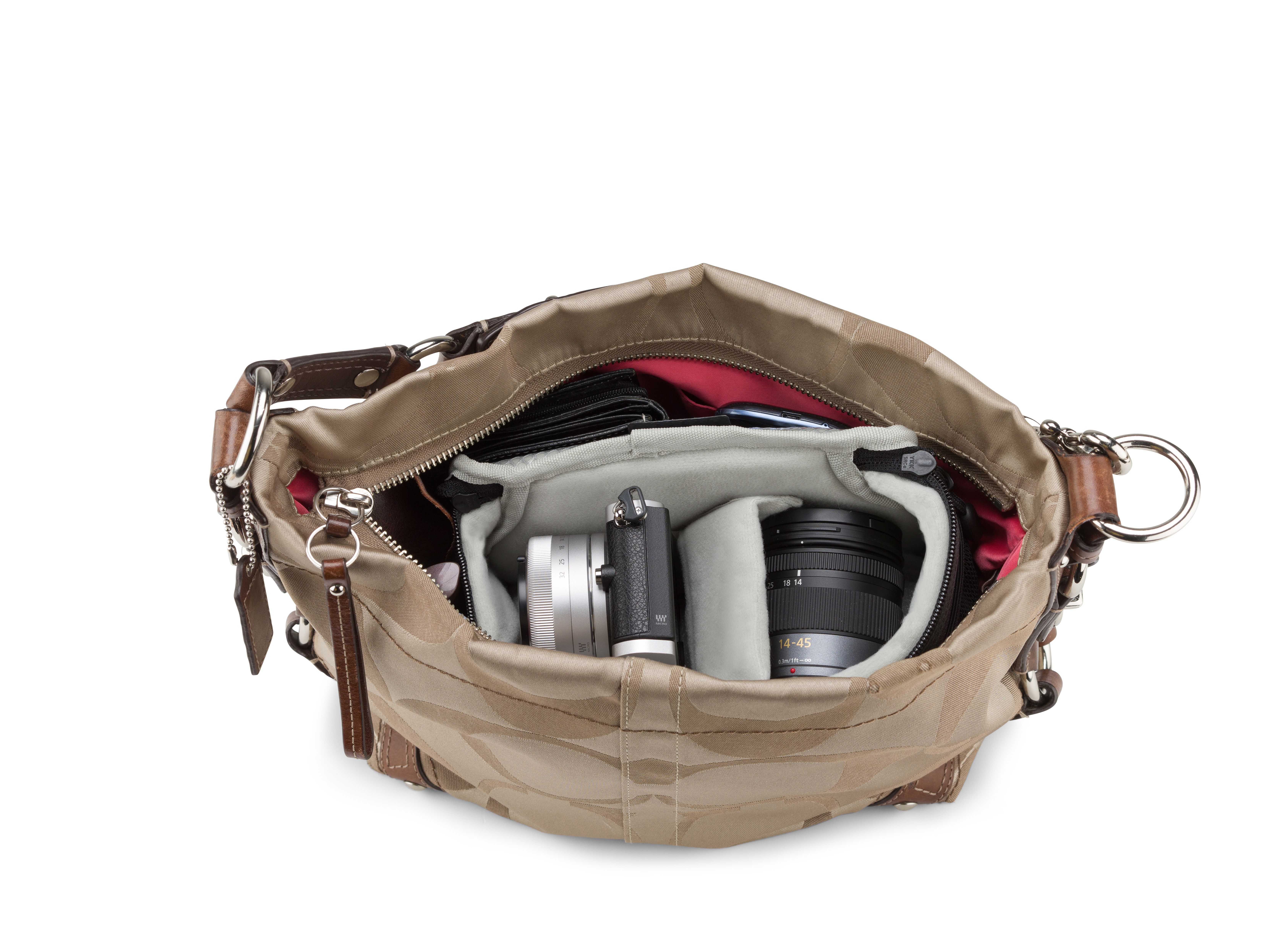 Eine geöffnete Handtasche mit Kamera, Objektiv und Zubehör im Inneren.