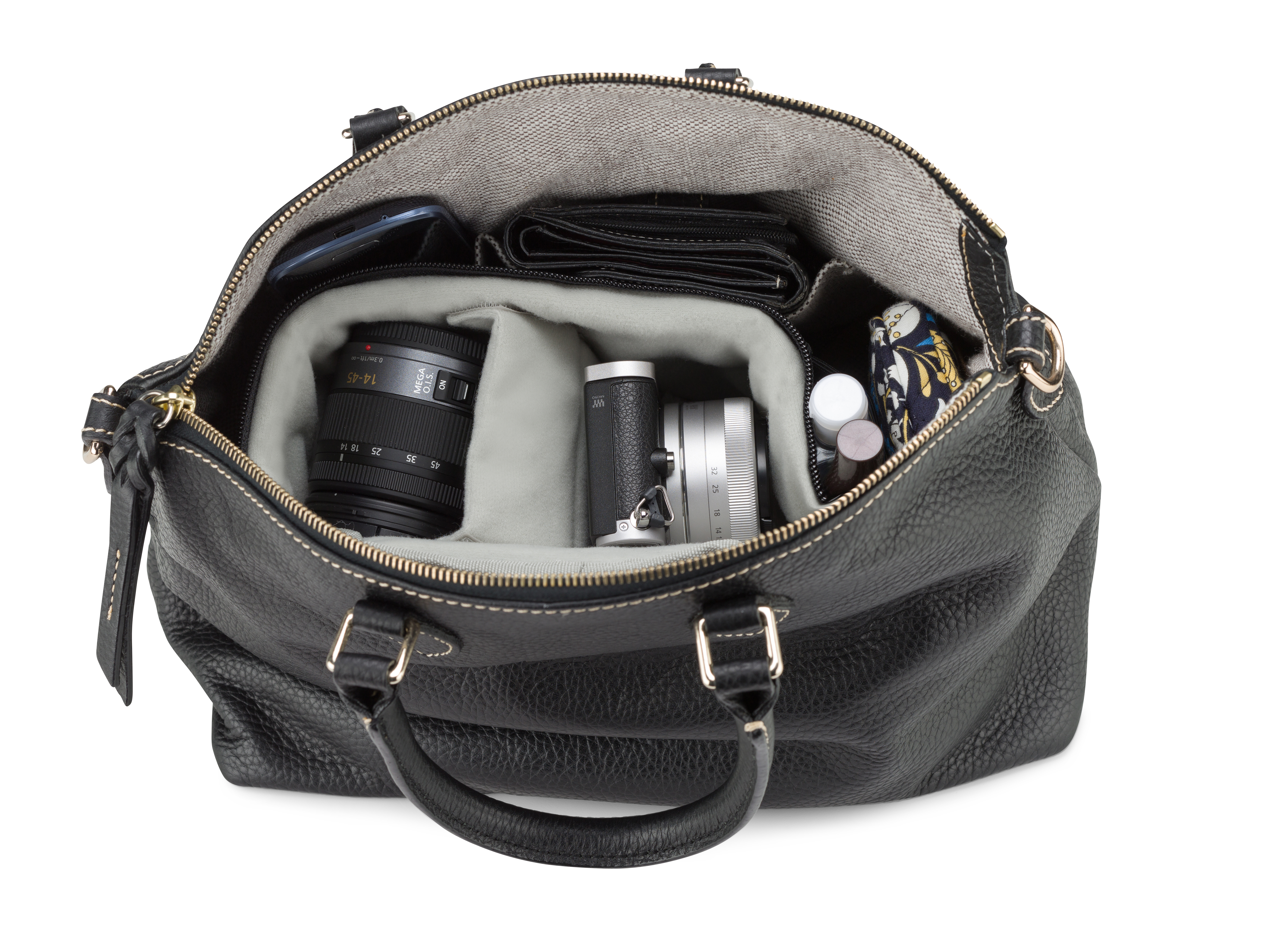 Eine schwarze Lederhandtasche, offen, mit Kameraobjektiven, einer Geldbörse, einem Telefon und anderen Gegenständen.
