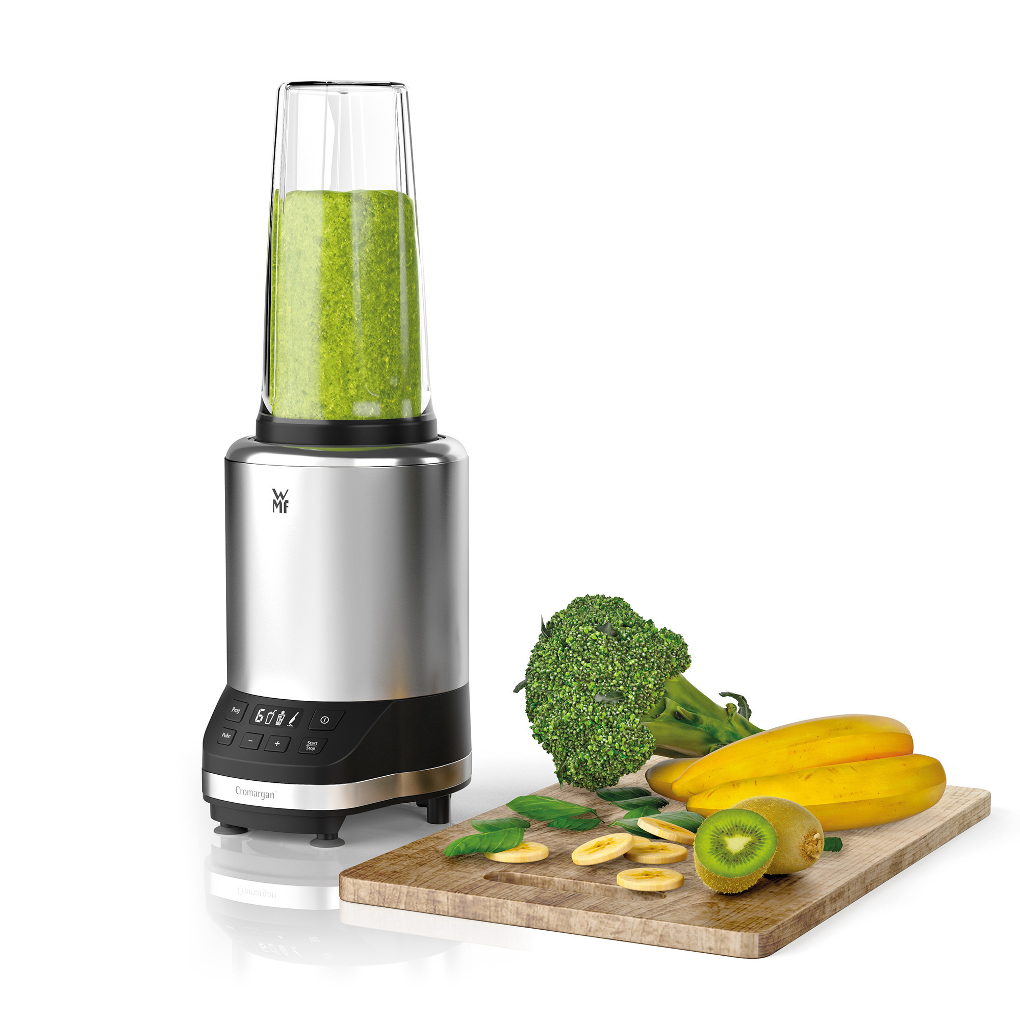Mixer mit grünem Smoothie, Brokkoli, Bananen und Kiwi auf einem hölzernen Schneidebrett.