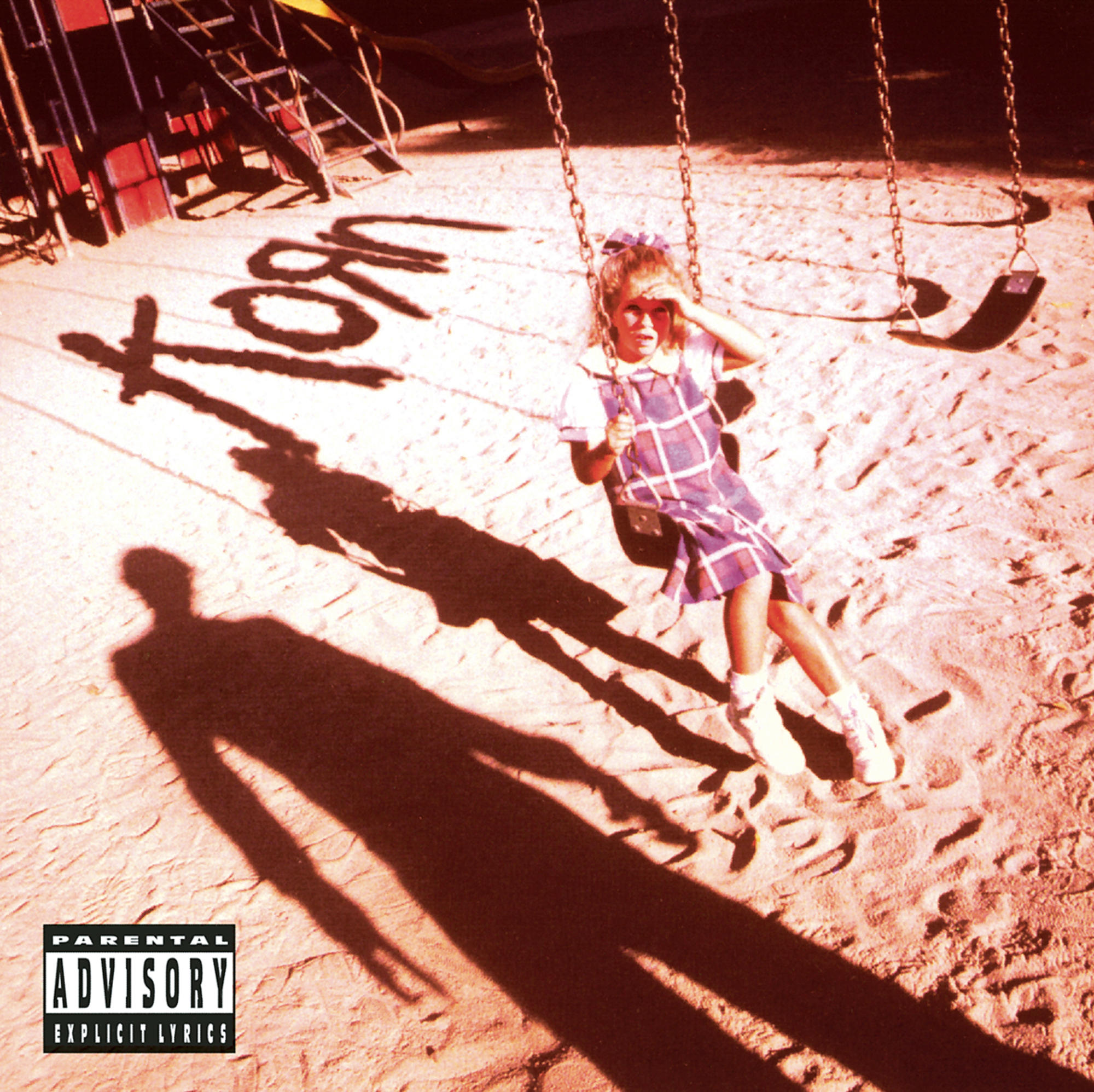 Albumcover für Korn. Mädchen auf Schaukel wirft Schatten. Korn ist im Sand geschrieben.