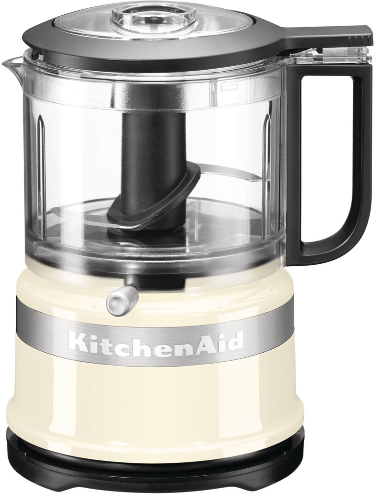 Un robot culinaire KitchenAid en ivoire et noir, avec un bol transparent et une poignée noire.
