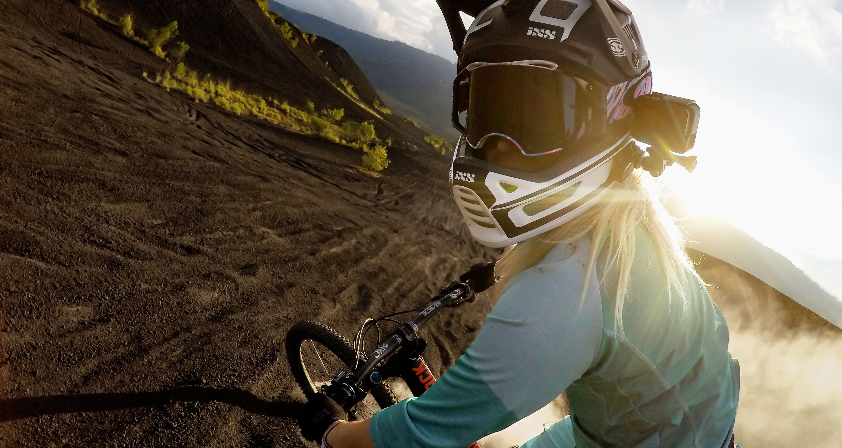 Egy személy mountain bike-kal lefelé hajt egy meredek lejtőn. A személy sisakot visel.