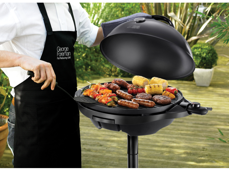 Egy fekete kötényes személy ételeket grillez egy fekete George Foreman grillen.