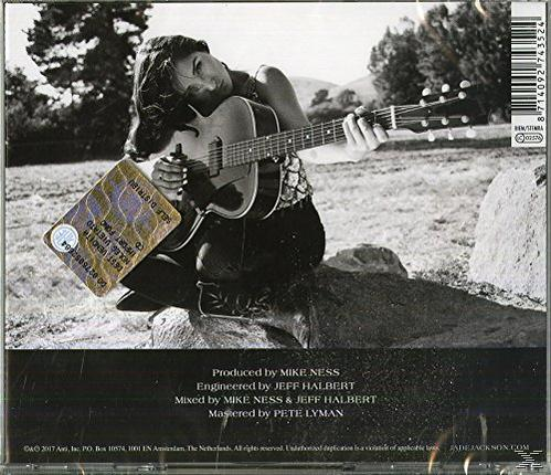 Rückseite einer CD. Eine Frau mit dunklen Haaren sitzt mit einer Gitarre, mit Text am unteren Rand.