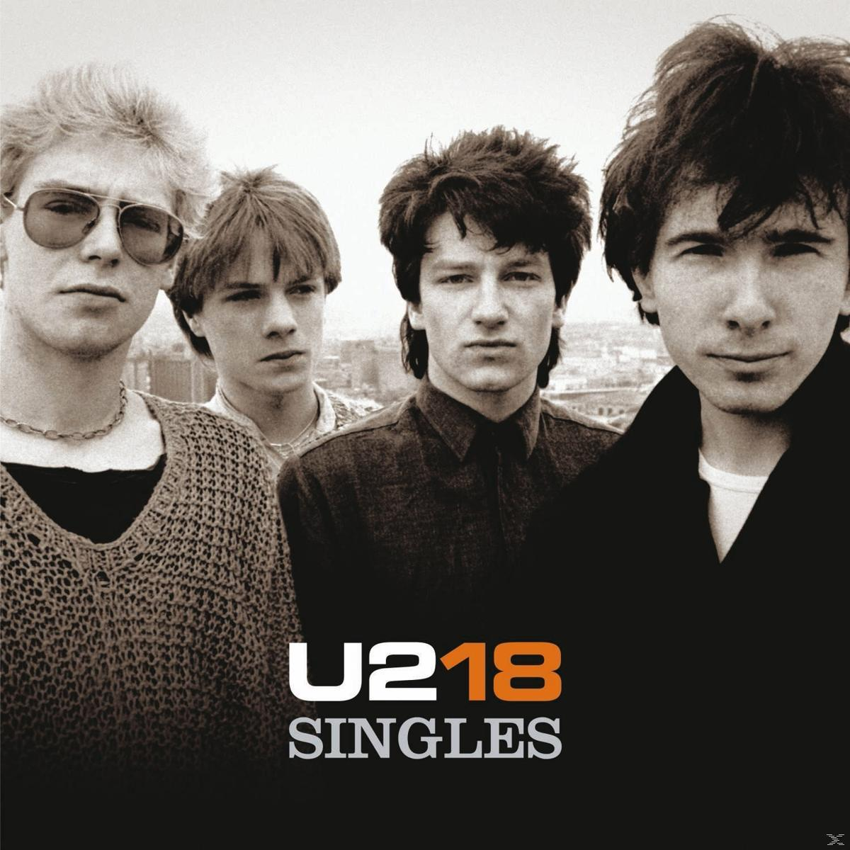 Albumcover von U2, vier Bandmitglieder, schwarz-weiß, posierend im Freien.