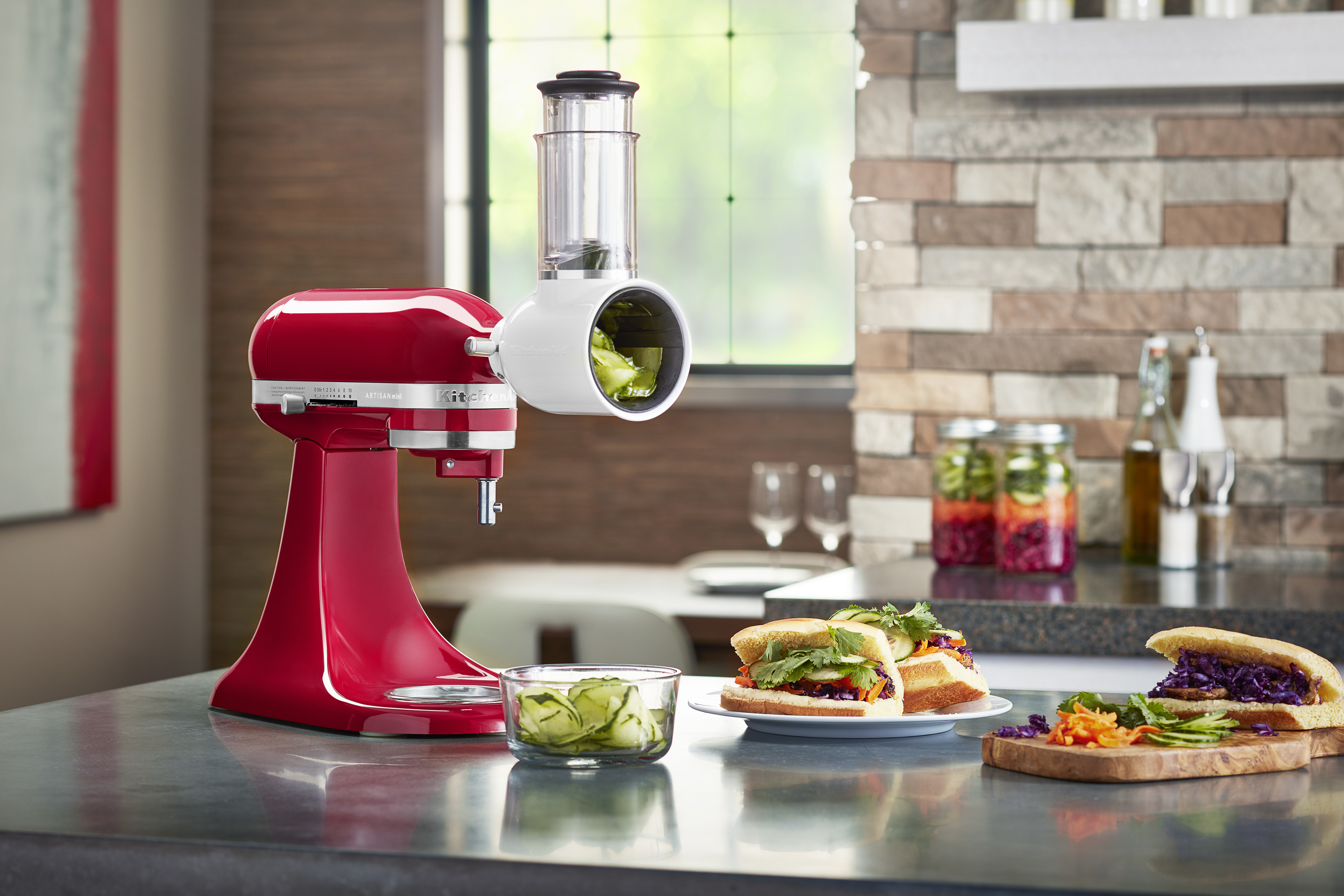 Ein roter KitchenAid-Mixer mit Fleischwolf-Aufsatz und Sandwiches.