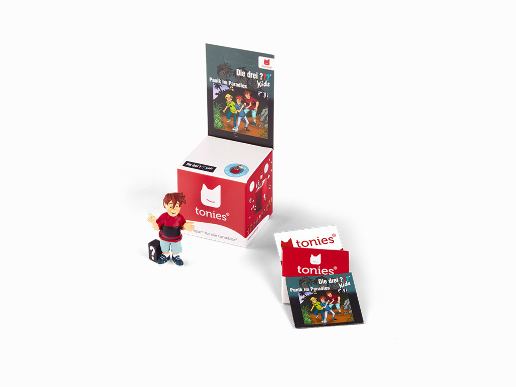 Eine Tonies-Box mit einer Figur und kleinen Karten. Die Box ist rot mit weißen Akzenten und trägt die Aufschrift 'tonies'.
