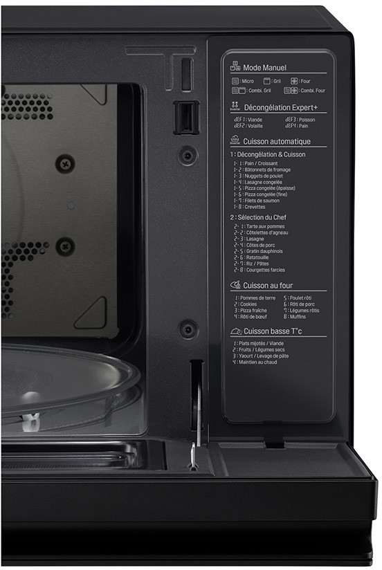 Close-up of a black microwave interior. The door is open, showing the inside and control panel.