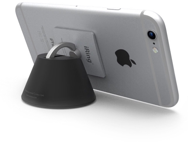 Un iPhone argenté avec un support annulaire noir attaché, reposant sur une base noire.